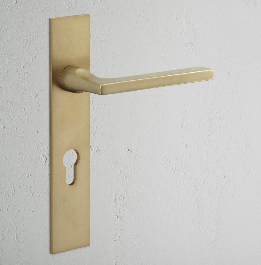 Clayton klamka do drzwi ze sprężyną, długim szyldem i profilem Euro mosiądz